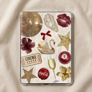 Op de afbeelding: Een doorzichtige tablethoes met een collage van iconen, waaronder een gouden discobal, een oester met een parel, rode lippen, een rode strik, een witte zwaan, een gouden glitterster, een bioscoopkaartje, een champagneglas, een biljartbal met nummer 7, een Coca-Cola-dop, een ster met luipaardprint en een gouden bloem.