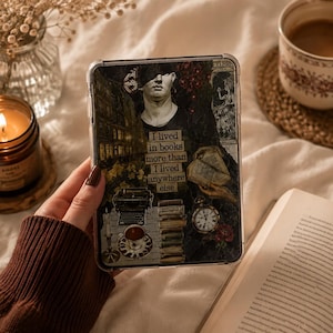 May include: A clear protective tablet case featuring a dark collage design with a classical statue bust, a typewriter, a stack of books, a pocket watch, and a teacup. The text reads: I lived in books more than I lived anywhere else.