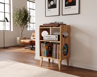 May include: A light brown wooden record player stand with four tapered legs, featuring three open shelves. The top shelf holds a turntable, the middle shelf holds a silver audio receiver, and the bottom shelf contains a collection of vinyl records.