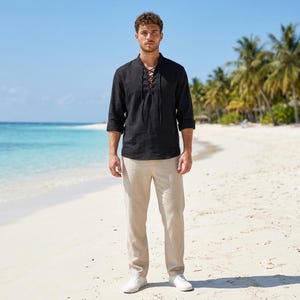 Pode incluir: Uma camisa preta de manga comprida com fecho frontal de atacadores e cal&ccedil;as bege. A camisa apresenta um decote em V com atacadores pretos finos atados num la&ccedil;o, e as cal&ccedil;as s&atilde;o de corte reto com cintura e bainha simples.