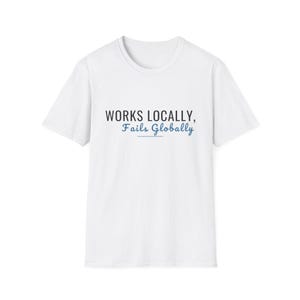 May include: A white short-sleeved t-shirt featuring the black text "WORKS LOCALLY," followed by the blue cursive text "Fails Globally" with a horizontal blue line underneath the text, centered on the chest of the garment.