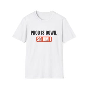 May include: A white short-sleeved t-shirt featuring the black text PROD IS DOWN, followed by the text SO AM I in white letters inside a red rectangular box. The shirt has a crew neckline and a standard fit, displaying a simple graphic design.