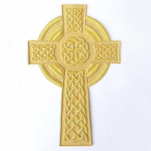 May include: A gold Celtic cross with intricate knotwork designs. The cross is surrounded by a circular halo with concentric rings.