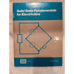 May include: A hardcover textbook titled Solid State Fundamentals for Electricians by Gary Rockis. The cover is blue and light gray, featuring a blue line drawing of an electrical circuit diagram with resistors and symbols.
