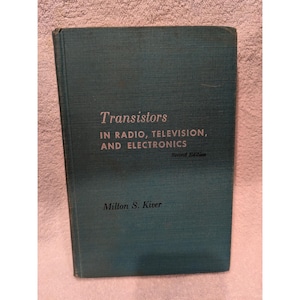 May include: A dark teal hardcover book titled Transistors IN RADIO, TELEVISION, AND ELECTRONICS Second Edition by Milton S. Kiver. The front cover features a textured fabric finish with the title and author name printed in a light color.