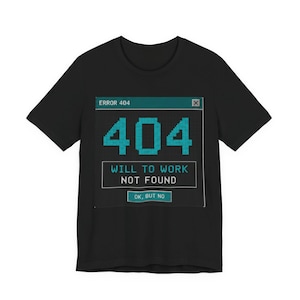 May include: A black short-sleeved t-shirt featuring a graphic of a computer error window. The text reads ERROR 404, 404, WILL TO WORK NOT FOUND, and OK, BUT NO. The design uses a teal and dark grey colour scheme with a pixelated font style.
