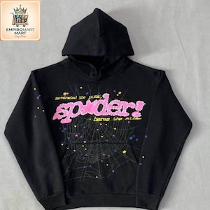 May include: A black hooded sweatshirt featuring a large pink graphic on the chest that reads "spider!" with the text "nevermind the punk, heres the slime" above and below. A spiderweb design with small colorful stars surrounds the text.