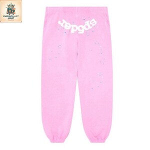 May include: Light pink sweatpants featuring a white graphic text logo that reads spider across the upper back area. The fabric is decorated with small, scattered blue and white paint-like speckles throughout the front surface of the garment.