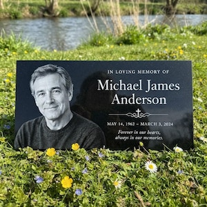 Peut inclure: Une plaque commémorative rectangulaire en granit noir avec un portrait gravé au laser d'un homme et le texte : IN LOVING MEMORY OF Michael James Anderson, une croix, MAY 14, 1962 - MARCH 3, 2024, Forever in our hearts, always in our memories.