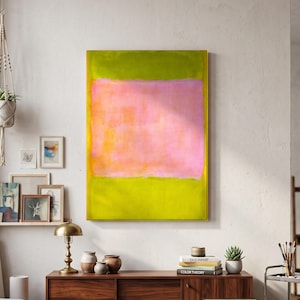 May include: A large rectangular canvas painting featuring a central horizontal block of soft pink surrounded by vibrant lime green on the top and bottom edges. The artwork is displayed on a white wall above a dark wood sideboard in a room.