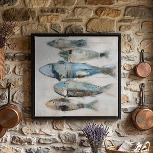 May include: A square framed wall art piece featuring a horizontal arrangement of five stylised fish in shades of blue, grey, and beige. The artwork has a textured, painterly appearance with visible brushstrokes, set against a neutral off-white background.