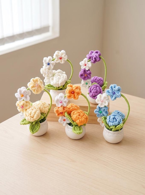 Tiny crocheted roses and daisies in a pot — genuinely handcrafted fiber art that looks surprisingly realistic and lasts forever unlike real flowers.