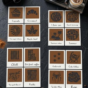 Puede incluir: Una colección de dieciséis tarjetas cuadradas con bordes blancos y centros marrones, cada una con un diseño negro recortado único y una etiqueta escrita a mano. Los diseños incluyen un cupcake, croissant, bagel, hoja de arce, frases de café, motivos de verano, un gatito, una araña y una rosa.