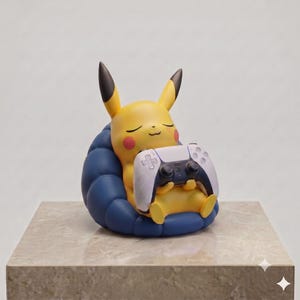 Pu&ograve; includere: Una statuetta gialla di Pikachu con orecchie a punta e guance rosse, seduta su una poltrona blu scuro, arrotondata e trapuntata. Il personaggio ha gli occhi chiusi con un'espressione pacifica e tiene in grembo un controller di gioco bianco e nero.