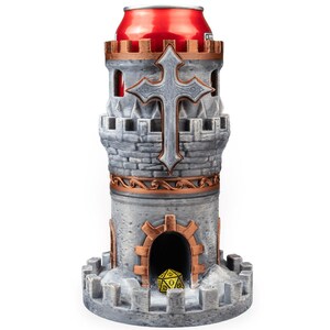 May include: A gray and copper-colored castle-shaped dice tower with a crenelated top and base. The structure features a prominent cross emblem on the front and a central arched doorway containing a single yellow twenty-sided die. A red can is inserted.