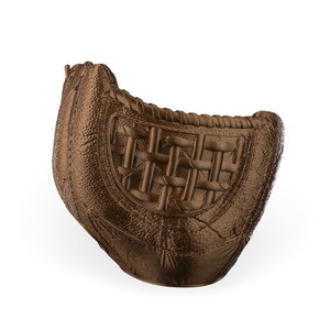 Puede incluir: Una secci&oacute;n de bolsillo de guante de b&eacute;isbol de cuero texturizado en color bronce que presenta un patr&oacute;n trenzado distintivo en el panel central. El art&iacute;culo muestra una forma curva semicircular con costuras visibles en los bordes y una superficie rugosa.
