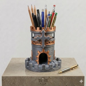 May include: A gray and copper-colored pencil holder shaped like a medieval castle tower with a cross emblem on the front. The cylindrical tower features a crenelated top and base, filled with various pens and pencils, with one gold pen lying nearby.