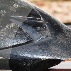 May include: A black wooden duck decoy with a carved head and a detailed paint job. The decoy has a black and gray paint scheme with a smooth finish.