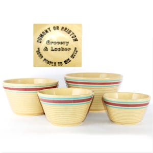 Puede incluir: Un juego de cuatro cuencos para mezclar de estilo vintage en varios tamaños. Los cuencos son de color crema con crestas horizontales y rayas rojas y turquesas. Un letrero de madera en la parte superior dice "Dumont or Bristow Grocery & Locker".