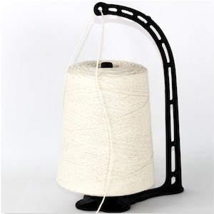 May include: A black yarn swift holds a large cone of off-white yarn. The yarn is unwinding from the cone. The swift has a curved arm and a base for stability. The background is plain white.