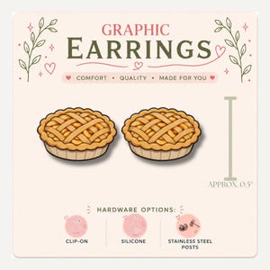 May include: A pair of pie-shaped graphic earrings on a display card labeled GRAPHIC EARRINGS. The pie design features a golden-brown lattice crust. A vertical bar indicates a size of approximately 0.5 inches. Hardware options include clip-on, silicone, and stainless steel posts.