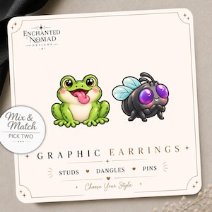 May include: A display card for Enchanted Nomad Designs featuring a green frog with a pink tongue and a fuzzy black bee with purple eyes. The card includes the text Mix & Match Pick Two, Graphic Earrings, Studs, Dangles, Pins, and Choose Your Style.