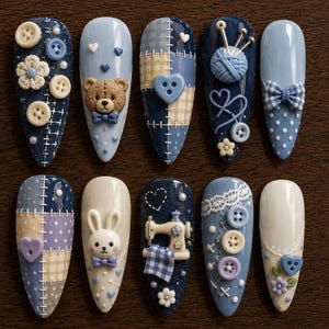 May include: A set of ten almond-shaped press-on nails featuring a blue and cream color palette with 3D embellishments including buttons, a teddy bear, a yarn ball with knitting needles, a rabbit, a sewing machine, bows, and lace patterns.