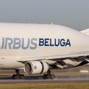 Può includere: Un aereo da trasporto Airbus Beluga con fusoliera bianca, un muso grande e bombato e scritte blu. Il numero 1 è stampato sul muso e sullo stabilizzatore verticale. L'aereo è dotato di due motori a reazione e di una pinna di coda blu.