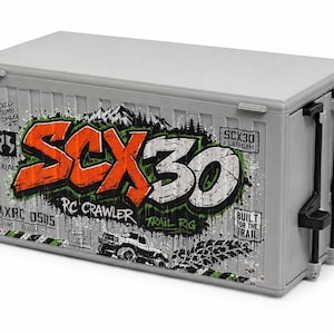 May include: A gray rectangular storage container designed like a shipping container with corrugated sides. It features the orange and white text SCX30, the words RC CRAWLER, TRAIL RIG, and BUILT FOR THE TRAIL, along with a graphic of a truck and mountains.