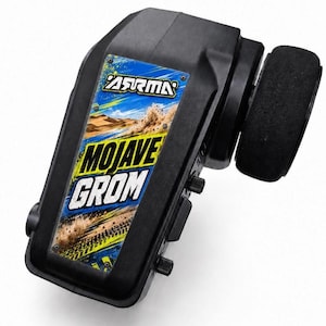 May include: A black radio control transmitter featuring a steering wheel on the side and a central panel with the text ARRMA and MOJAVE GROM over a graphic of a desert landscape with tire tracks and splashes of blue and yellow paint.