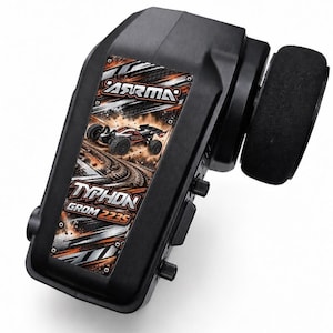 May include: A black radio control transmitter featuring a steering wheel on the side and a central graphic panel. The panel displays the text ARRMA, TYPHON, and GROM 223S, along with an illustration of an off-road vehicle on a dirt track.