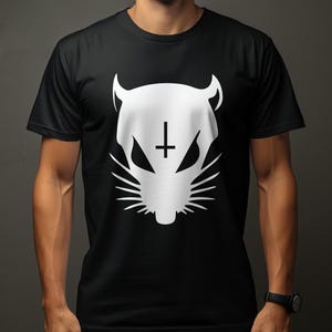 May include: A black short-sleeved t-shirt featuring a large white graphic print on the chest. The graphic depicts a stylized animal head with pointed ears, sharp eyes, whiskers, and an inverted cross symbol positioned between the eyes.