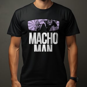May include: A black short-sleeved t-shirt featuring a graphic print of sunglasses with a purple sunburst pattern and a portrait of a person inside the lenses. Below the sunglasses, the text MACHO MAN is printed in large, bold, white capital letters.