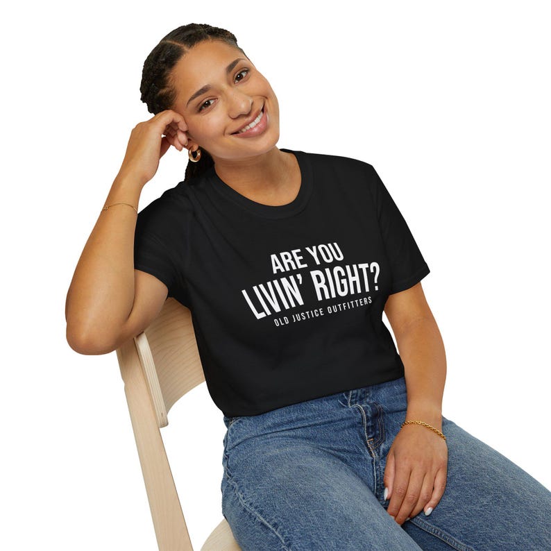 Model wearing a black Old Justice Outfitters T-shirt with white ARE YOU LIVIN’ RIGHT? lettering on the front.
