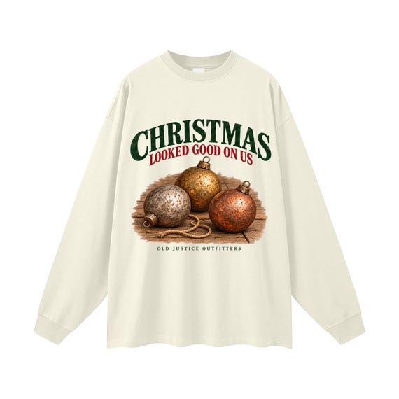 Milk Tea long-sleeve shirt printed with antique-style ornaments on worn wood with loose twine and the words Christmas Looked Good on Us.
