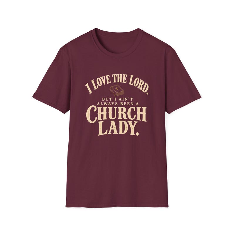 Maroon short-sleeve T-shirt with cream and gold lettering and a small Bible reading I LOVE THE LORD. BUT I AIN’T ALWAYS BEEN A CHURCH LADY.