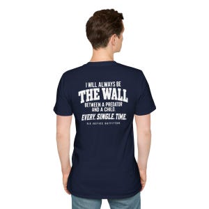May include: A navy blue short-sleeved t-shirt featuring white text on the back that reads: I WILL ALWAYS BE THE WALL BETWEEN A PREDATOR AND A CHILD. EVERY. SINGLE. TIME. OLD JUSTICE OUTFITTERS. The shirt has a crew neckline and a standard fit.