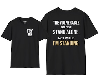 May include: A black short-sleeve t-shirt featuring the white text TRY ME on the front chest. The back displays the white text THE VULNERABLE DO NOT STAND ALONE. NOT WHILE I'M STANDING, with the final word in a light gold color.