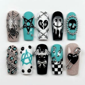 May include: A set of ten press-on nails featuring diverse designs including a spider web, a black star, a broken heart with barbed wire, a dripping smiley face, a skull, leopard print with chains, an anarchy symbol, a bat, music notes, and a heart.