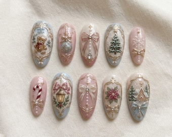 May include: A set of ten almond-shaped press-on nails featuring intricate Christmas-themed designs. The nails are decorated with gold filigree frames, a teddy bear, a candy cane, a Christmas tree, a lantern, a poinsettia, and bows.