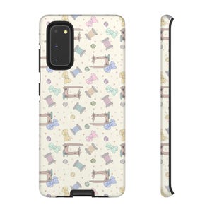 May include: A phone case with a repeating pattern of sewing machines, spools of thread, bows, and buttons in pastel colors. The case is off-white with a black camera and button area.