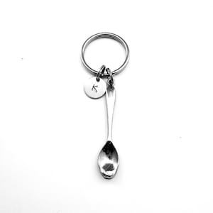 May include: Silver spoon keychain with a silver letter K charm attached to a silver key ring.