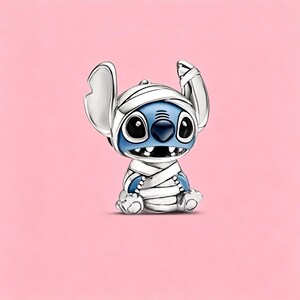 May include: A silver-toned metal charm shaped like the character Stitch, depicted with blue skin and large black eyes, wrapped in white bandages across the head and body. The charm features a glossy finish with detailed engraved lines.