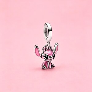 May include: A silver charm bead featuring a stylized character with large ears, pink enamel accents on the ears and body, and black enamel eyes. The charm has a circular bail at the top with the engraving S925, indicating sterling silver composition.