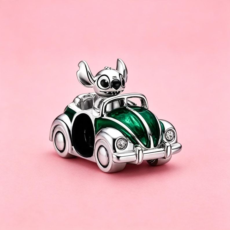 May include: A silver-toned charm shaped like a convertible car with a green hood and trunk. A small character with large ears and black eyes sits in the driver seat. The car features two clear, sparkling stones as headlights on the front bumper.
