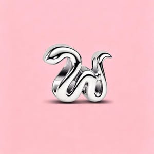 May include: A polished silver-tone metal charm shaped like the lowercase letter w. The design features a smooth, fluid, and rounded aesthetic with a reflective surface that catches light, creating high-contrast highlights and deep shadows.