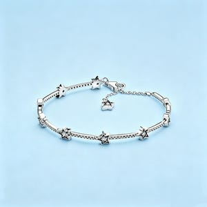 May include: A silver-toned chain bracelet featuring multiple star-shaped charms embedded with small clear stones. The bracelet includes a delicate extender chain with a single star charm dangling from the end and a secure lobster claw clasp.