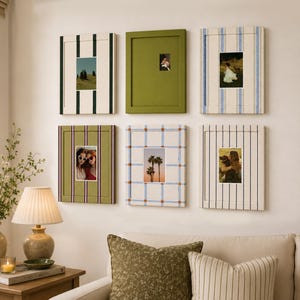 May include: A collection of six rectangular wall-mounted picture frames arranged in two rows. The frames feature various patterns including vertical stripes, a solid olive green finish, and a blue grid design, each holding a small photograph.