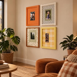 May include: Four rectangular wall frames arranged in a grid. Top left is orange, top right is white with a beaded edge, bottom left is brown with a leaf pattern mat, and bottom right is yellow with a plaid mat. Each frame holds a photograph.