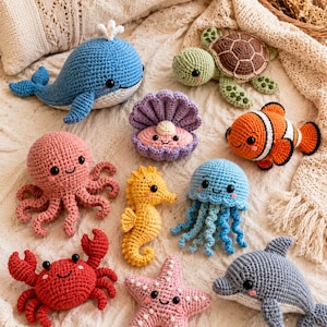 Peut inclure: Une collection de dix créatures marines en crochet faites à la main, comprenant une baleine bleue, une tortue verte, un palourde violette avec une perle, un poisson-clown orange, une pieuvre rose, un hippocampe jaune, une méduse bleue, un crabe rouge, une étoile de mer rose et un dauphin gris.